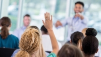 Woman asks question during a continuing education program.